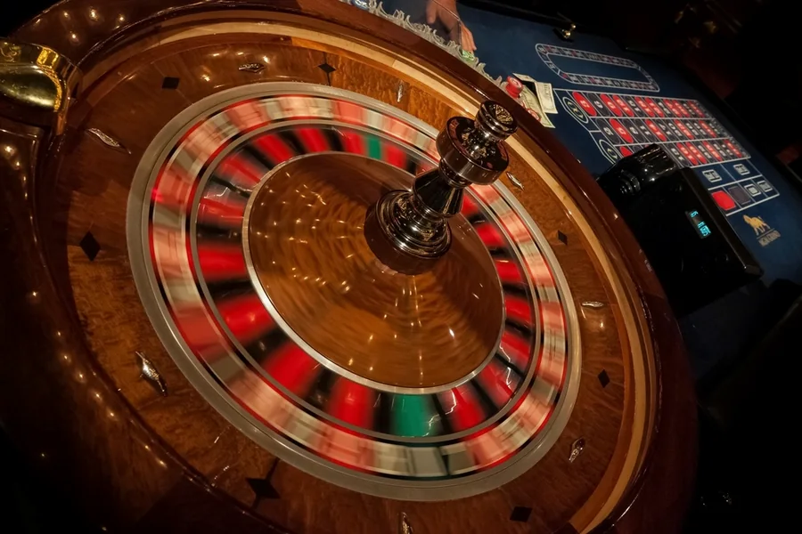 A roulette wheel mid-spin, bets still on the layout